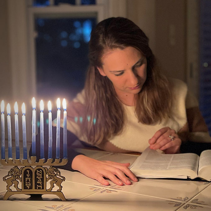 Woman reading Maccabees on Hanukkah