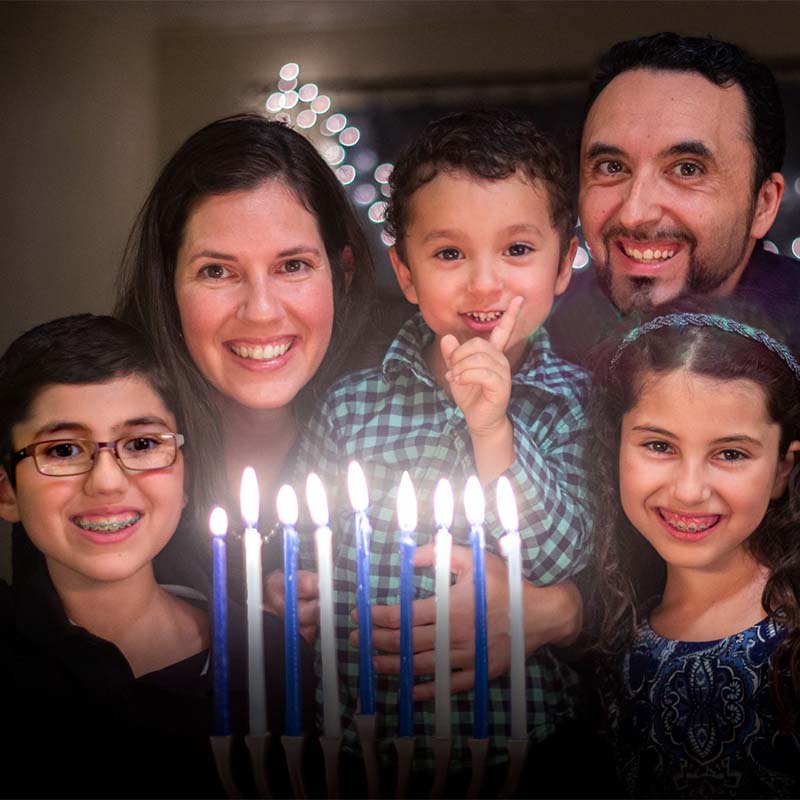 Emmanuel celebrating Hanukkah with his family
